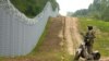 Супрацоўнік латвійскага спецпадраздзялення патрулюе агароджe на латвійска-беларускай мяжы, 8 жніўня 2023