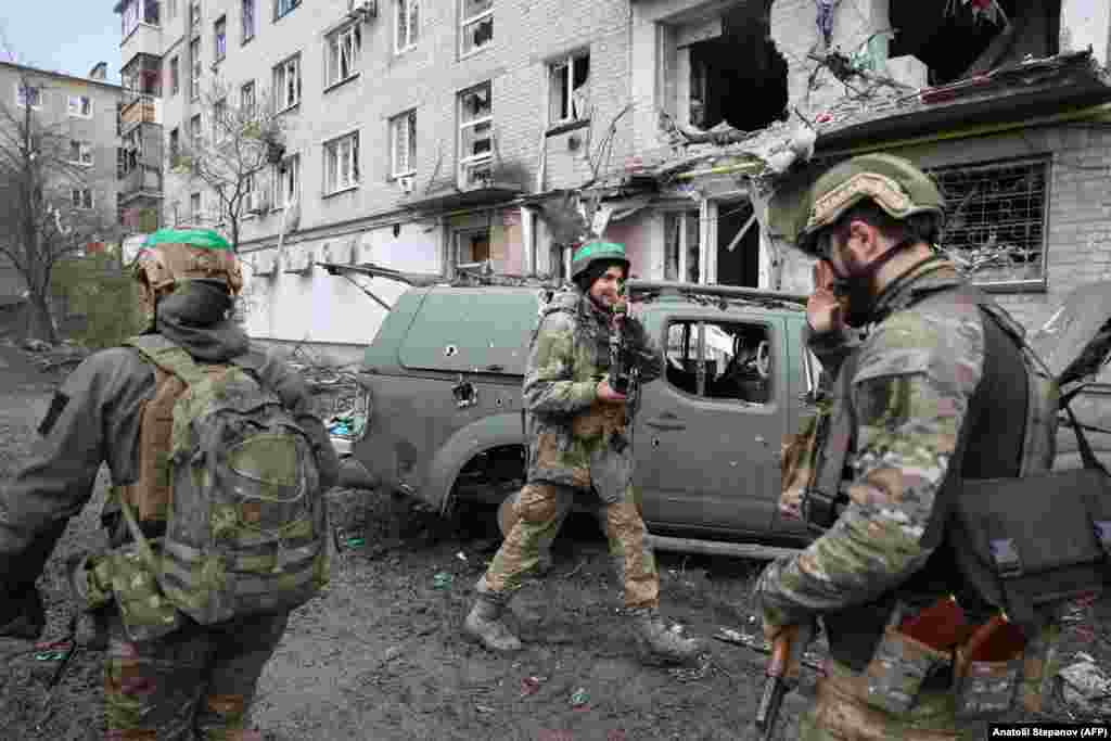 Un soldat face semnul victoriei către un camarad, în partea de vest a orașului Bahmut, cea&nbsp; controlată de Ucraina. Analiștii consideră că Bahmutul are o valoare strategică redusă, dar a căpătat o semnificație politică în condițiile în care ambele tabere continuă cea mai sângeroasă bătălie de infanterie de după Al Doilea Război Mondial.