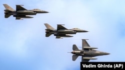 Avioane de vânătoare F-16 ale Forțelor Aeriene Române efectuează o trecere la Marea Neagră, în cadrul expoziției internaționale de Apărare, Aerospațială și Securitate (BSDA) de la București, România, 22 mai 2024.