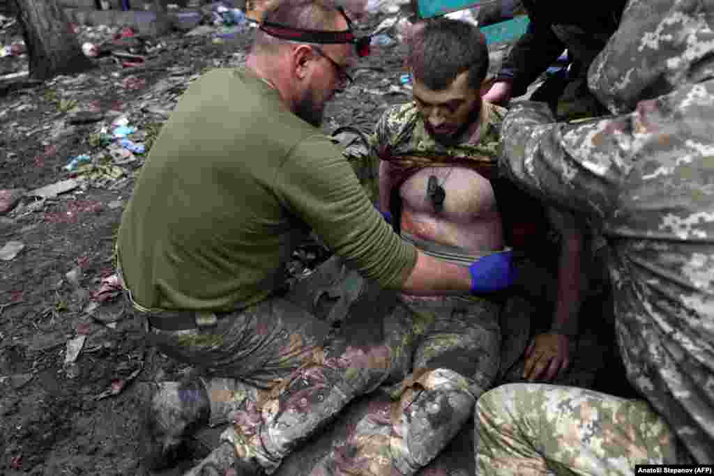 Paramedicii militari tratează un soldat ucrainean rănit. &bdquo;Fiecare zi în care rezistăm aici dă timp altor unități să se pregătească pentru un contraatac&rdquo;, a adăugat Filosoful. &bdquo;Noi suntem vulnerabili pentru că nu mai avem obuze&rdquo;.
