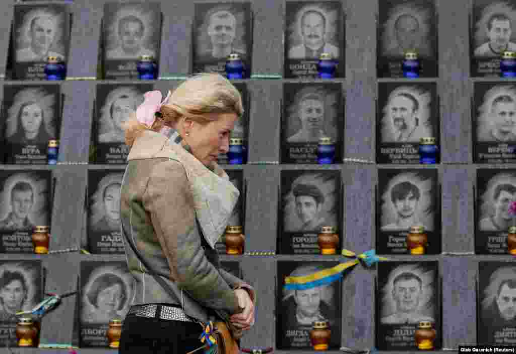 2014 жылы Киевтің тәуелсіздік алаңында (Майдан незалежности) билікке қарсы жаппай наразылық кезінде үкімет күштерінің оғынан қаза тапқан &quot;Небесная сотня&quot; қаһармандары құрметіне орнатылған ескерткіштің алдында тұрған әйел.