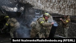 Soldiers from the 15th Brigade of Ukraine's National Guard of Ukraine fire artillery near Kupyansk in May. 