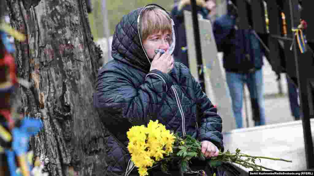 &quot;Небесная сотня&quot; қаһармандары құрметіне қойылған ескерткіш алдында көзіне жас алып тұрған әйел.