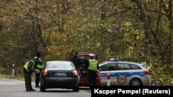 Польскія паліцыянты аглядаюць транспартныя сродкі на кантрольна-прапускным пункце пры ўезьдзе ў забароненую зону надзвычайнага становішча, 14 кастрычніка 2021 году