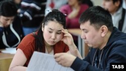 Мигранты во время экзамена на знание русского языка в миграционном центре