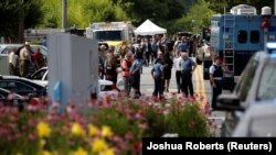 Қарулы шабуыл жасалған Capital Gazette басылымы редакциясы маңында тұрған адамдар. Аннаполис қаласы, Мэриленд штаты, 28 маусым 2018 жыл.