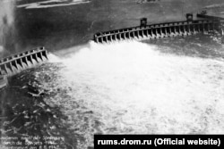 Apa se revarsă prin barajul DniproHES după ce forțele Armatei Roșii l-au distrus în timpul retragerii.