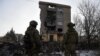 Militari ucraineni lângă o clădire cu apartamente grav avariată de un atac militar rusesc în Bahmut 
