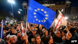 დემონსტრანტები პარლამენტის წინ საპროტესტო აქციაზე "არა რუსულ კანონს!" საქართველოს და ევროკავშირის დროშებით." 15 აპრილი, 2024.