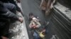 SYRIA -- Civil defence help an unconscious woman from a shelter in the besieged town of Douma in eastern Ghouta in Damascus, February 22, 2018