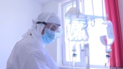 Медицинский работник в маске в больнице для пациентов с COVID-19 и «ковидоподобной пневмонией».