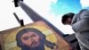 Иса пайғамбардың суретінің алдында тұрған әйел. Мәскеу, 30 қазан 2015 жыл. (Көрнекі сурет.)