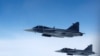 Imagine generică - Avioane de vânătoare Saab JAS 39 Gripen ale Forțelor Aeriene Suedeze zboară alături de o aeronavă care simulează interceptări aeriene 