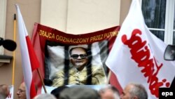 Праціўнікі Ярузэльскага нясуць плякат "Здраднік, узнагароджаны Пуціным"