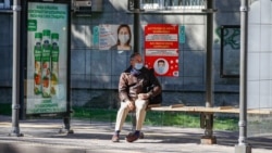 Мужчина на автобусной остановке в Алматы.