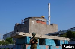 Российский военный на фоне Запорожской АЭС